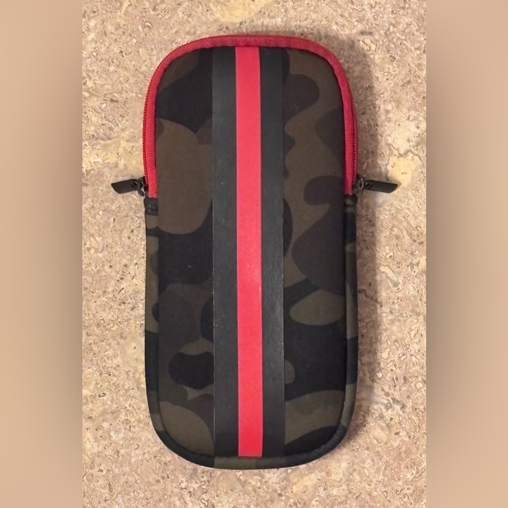 The Haute Shore Sunglasses Neoprene Case in green camouflage with a red stripe